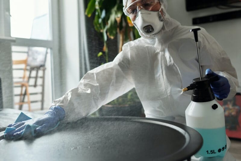 a person cleaning with disinfectant spray