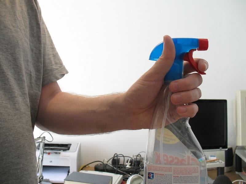 a person holding spray bottle
